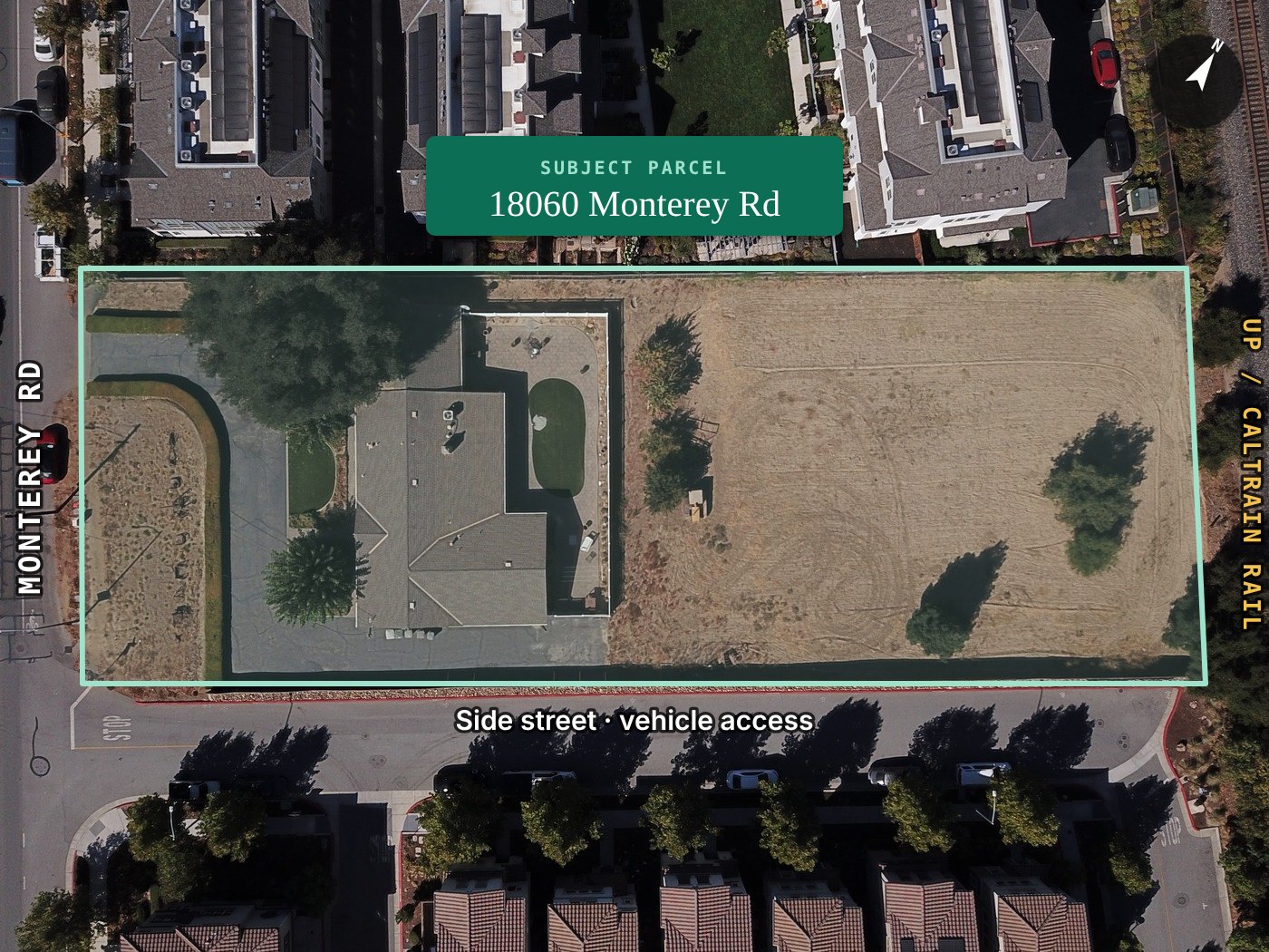 October 2026 drone photograph straight down over 18060 Monterey Road with the approximate parcel boundary outlined in mint, Monterey Road at left, the rail line at right and the side street below