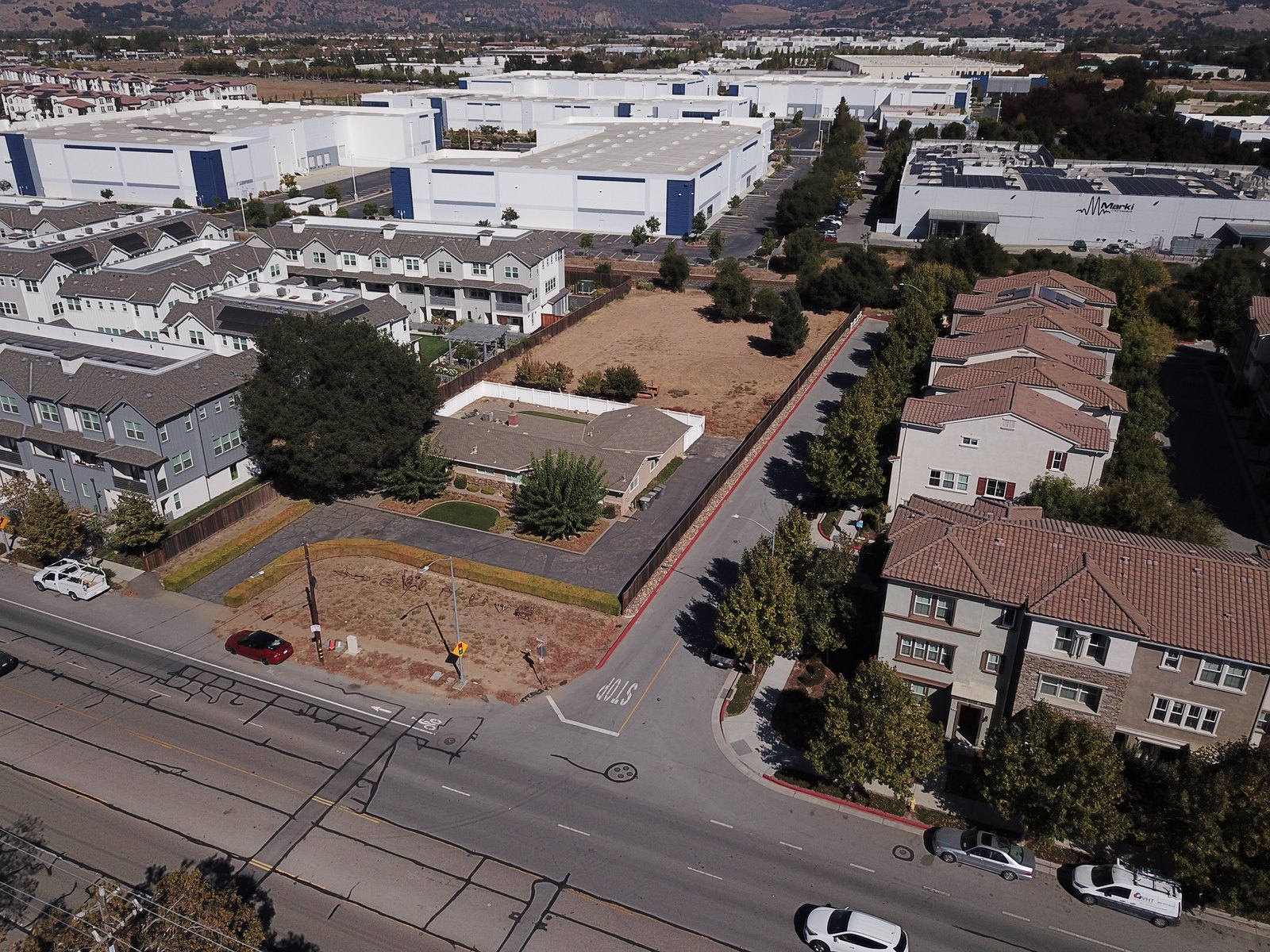 October 2026 drone photograph of the existing 1969 home and open land at 18060 Monterey Road, from the Monterey Road and side-street corner